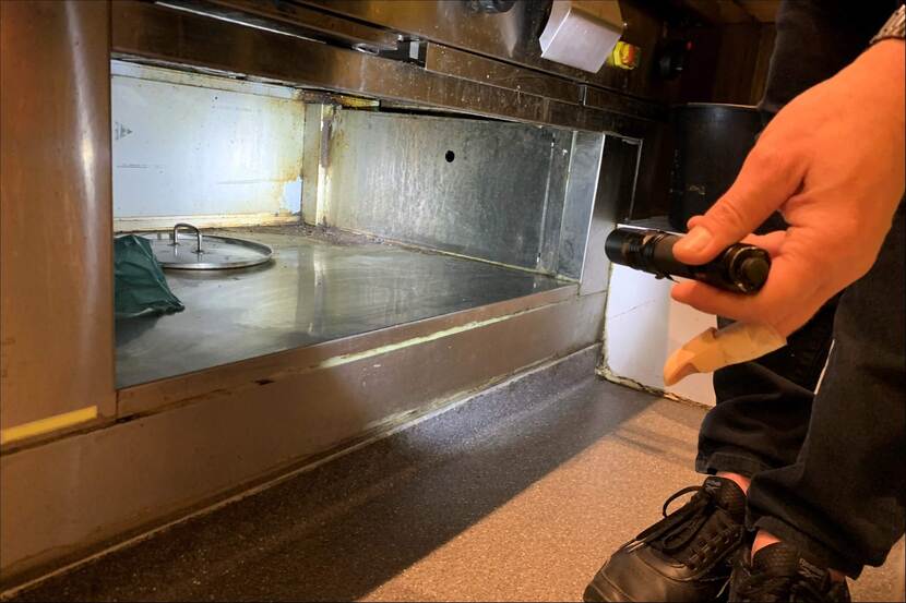NVWA-medewerker inspecteert opbergruimte in horecakeuken