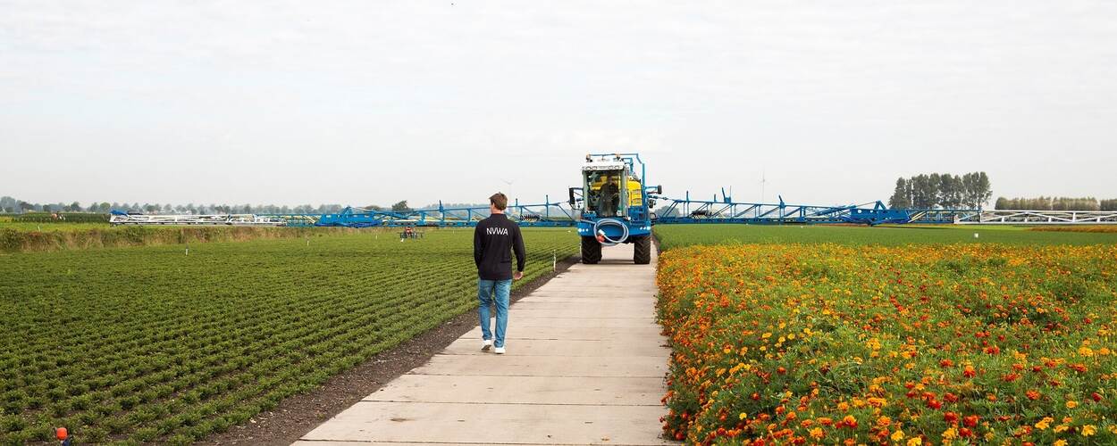 NVWA inspecteur in veld met spuitmachine