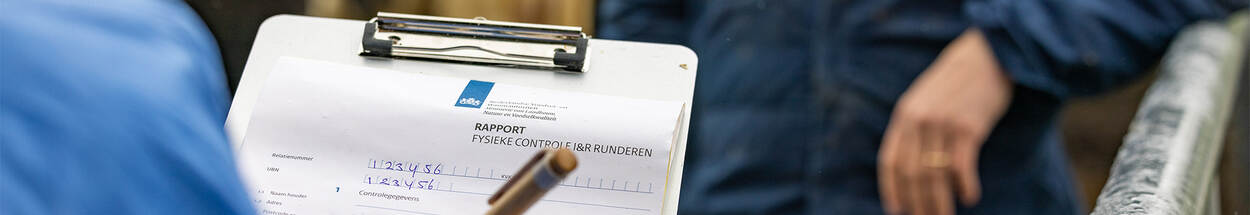 NVWA Inspecteur schrijft rapport met boer in koeienstal