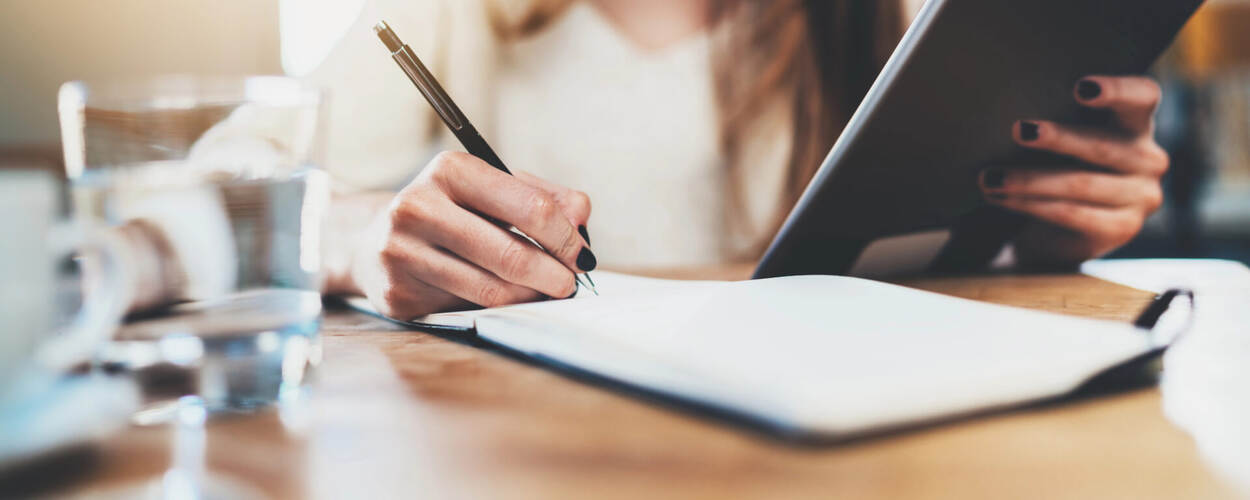 Vrouw schrijft in een notitieboek