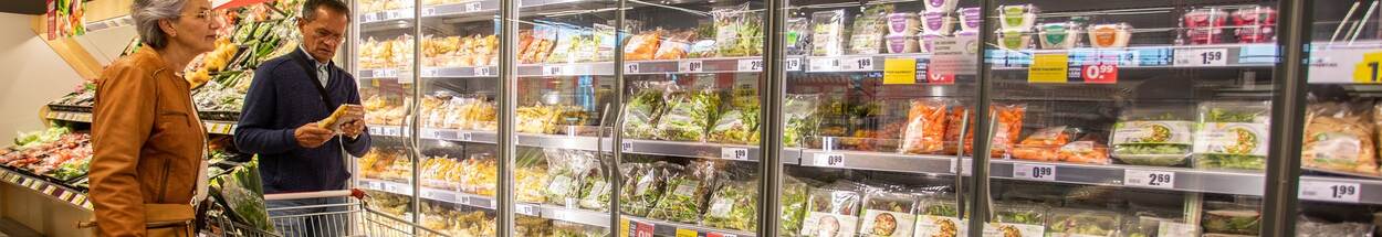 Twee klanten bij de koeling in de supermarkt