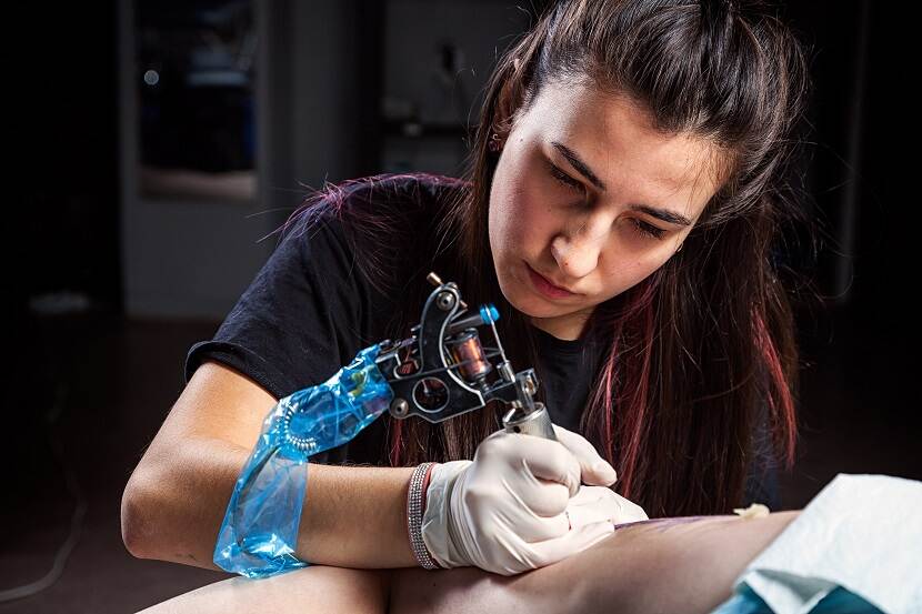 Vrouw tatoeeert arm