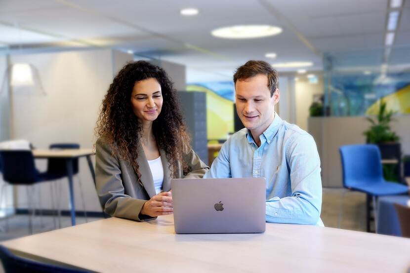 Twee NVWA collega's achter een laptop op kantoor