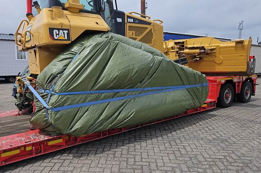 Voertuig op vrachtwagen in zeil gewikkeld